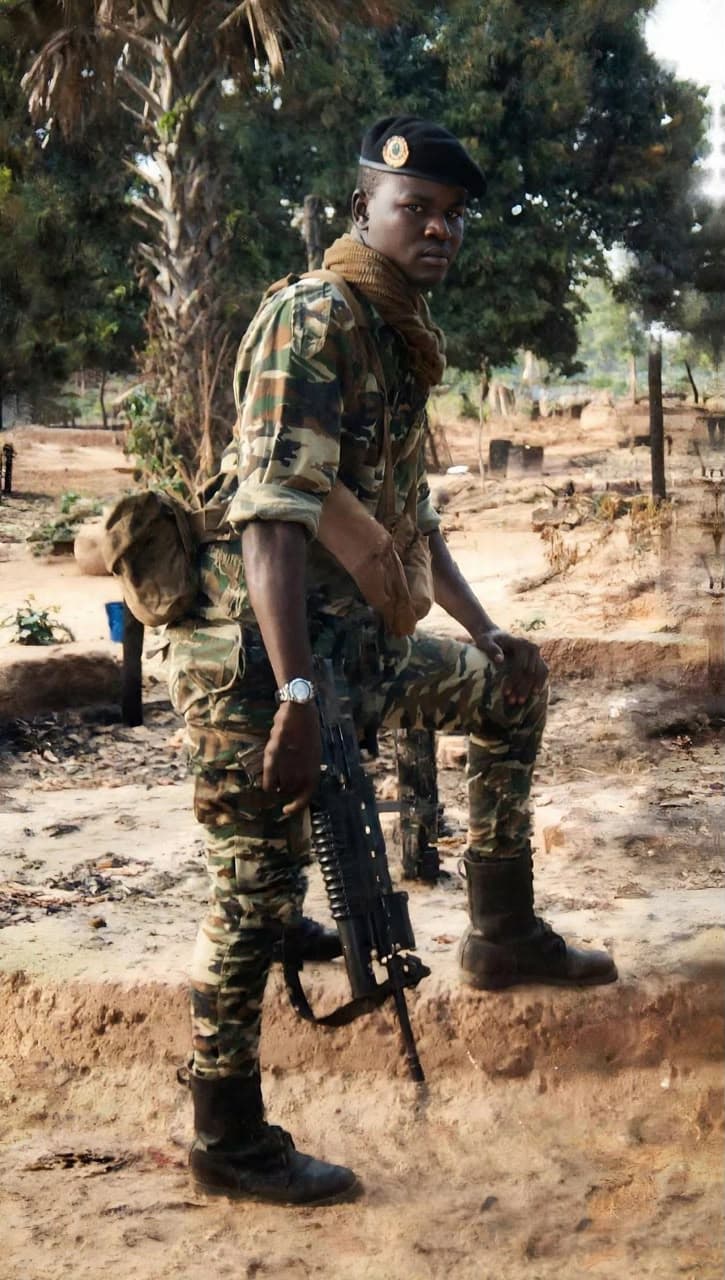 Soldat de l'Armée sénégalaise en faction, arme à la main, béret et treillis.